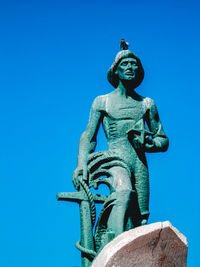 Low angle view of statue against blue sky