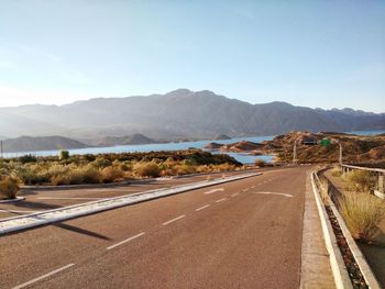 Road leading towards mountains against sky