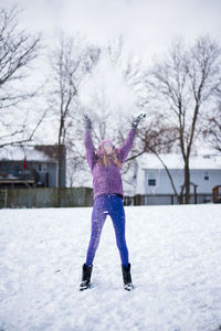 Pre teen throwing snow in the air outside in winter