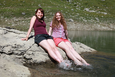 Portrait of a smiling young woman sitting in water