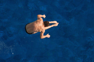 Directly above shot of man jumping in swimming pool
