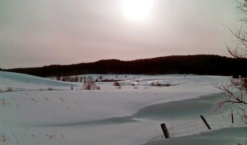 Scenic view of frozen landscape against clear sky during winter