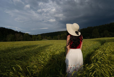 Rear view of woman standing on field