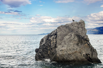 Scenic view of rock formation in sea against sky