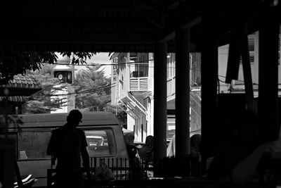 Silhouette of man sitting at restaurant of building