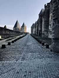 Cobblestone street amidst buildings against sky