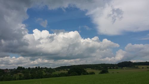 Scenic view of grassy field against cloudy sky