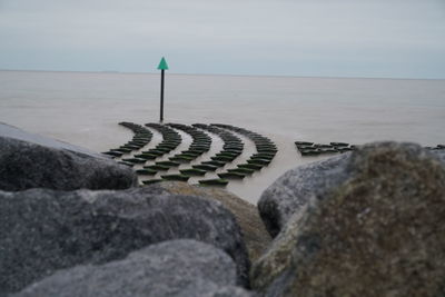 Rocks on beach against sky