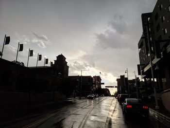 Cars on road amidst buildings in city against sky