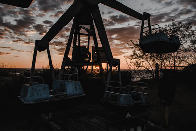 Empty ferris wheel against sky during sunset