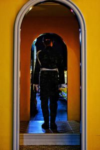 Rear view of woman standing at entrance of building