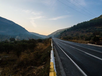 Highway by mountain against clear sky