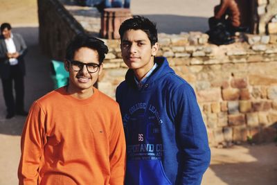 Portrait of friends standing against old ruins