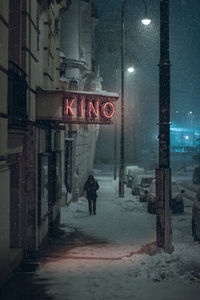 Text on snow covered road at night