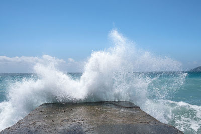 View of waves breaking against sea
