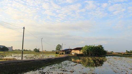 Scenic view of river by building against sky