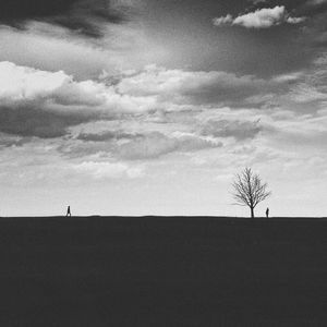 Silhouette people on field against sky