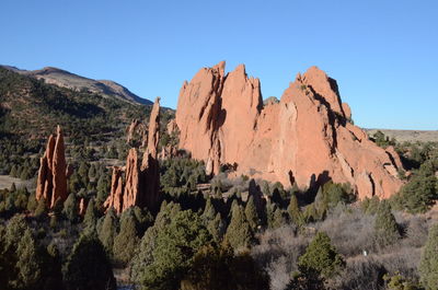 Panoramic view of rocky mountains against clear blue sky