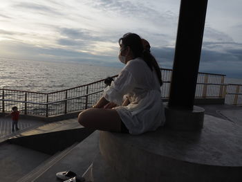 People looking at sea against sky