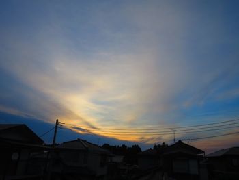 Low angle view of houses against sky at sunset