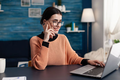 Young woman using laptop at home