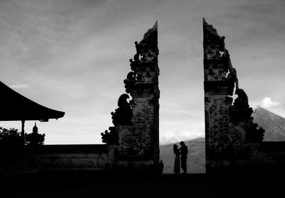 Silhouette people at historic building against sky