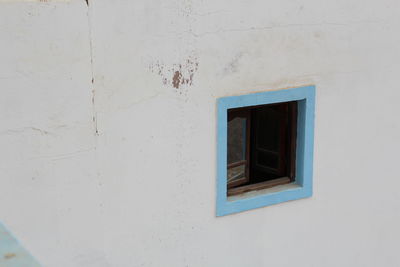 High angle view of blue window amidst white wall