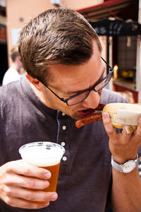 Close-up of young man having food and drink outdoors