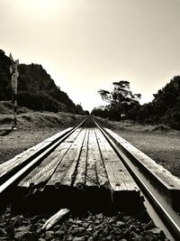 Railroad tracks by trees against sky