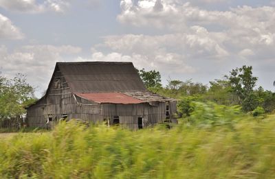 Abandoned building on field against sky