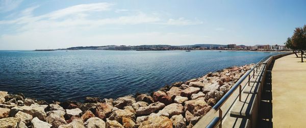 Panoramic view of river and rocks against sky on sunny day