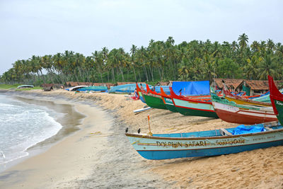 Boats moored on beach against sky