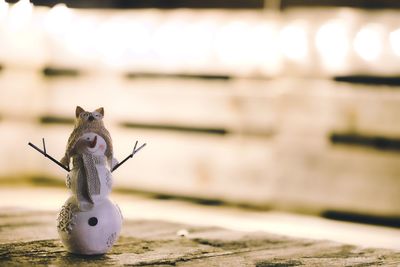 Christmas snowman on table in front of light decoration