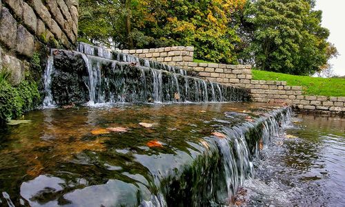 Scenic view of waterfall against sky