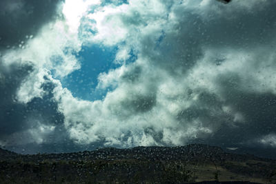 Low angle view of storm clouds over mountain