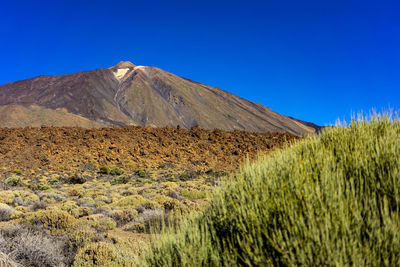 Scenic view of mountains against clear blue sky