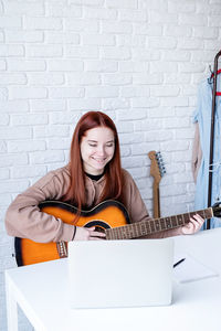 Portrait of young woman using laptop at home