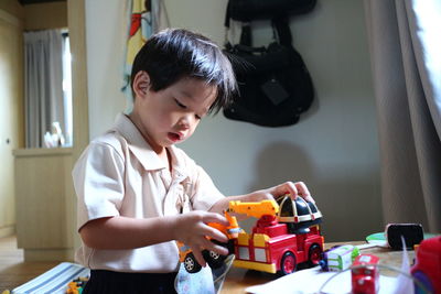 Portrait of boy playing with toy truck