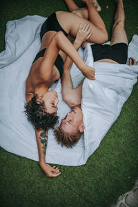 High angle view of friends sleeping on bed