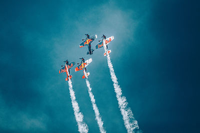 Low angle view of airplane flying against blue sky