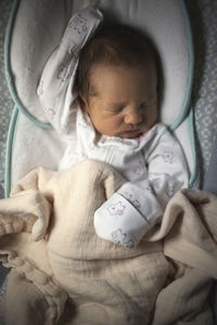 Overhead view of baby girl sleeping in crib at home