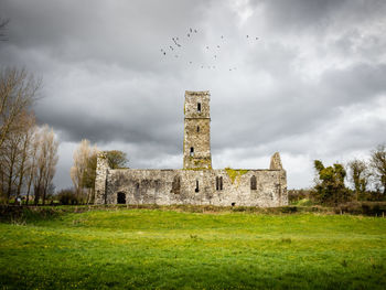 Old building on field against sky