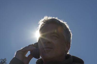 Low angle portrait of man against clear sky