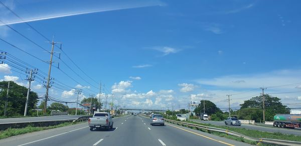 Cars on road against sky in city