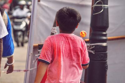 Rear view of father with son standing in city