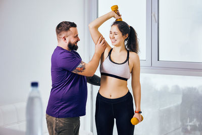 Fitness instructor training woman in gym