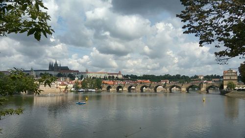 Bridge over river in city against sky