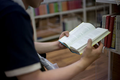 Midsection of man holding book