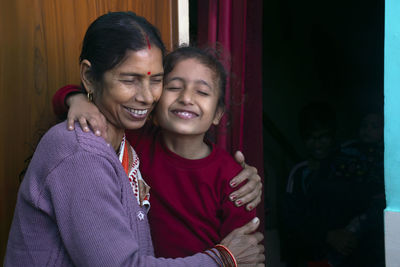 Happy grandmother and granddaughter hugging each other, india