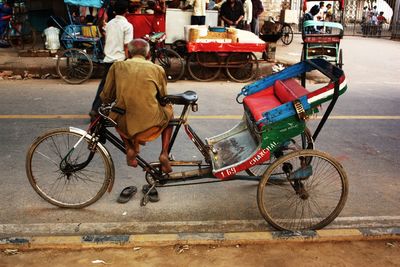 Rear view of man sitting on pedicab